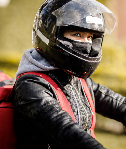 Entregador de moto usando capacete e mochila, profissão que exige visão completa e pode ter direito a auxílio-doença em caso de visão monocular.