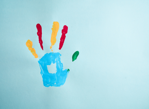 Mão colorida com tintas representando inclusão e diversidade, simbolizando o direito ao LOAS para pessoas com autismo.