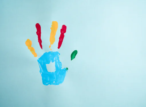 Mão colorida com tintas representando inclusão e diversidade, simbolizando o direito ao LOAS para pessoas com autismo.